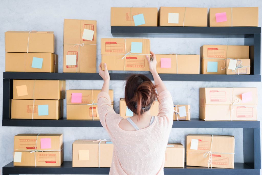 Girl pulling out box from shelf