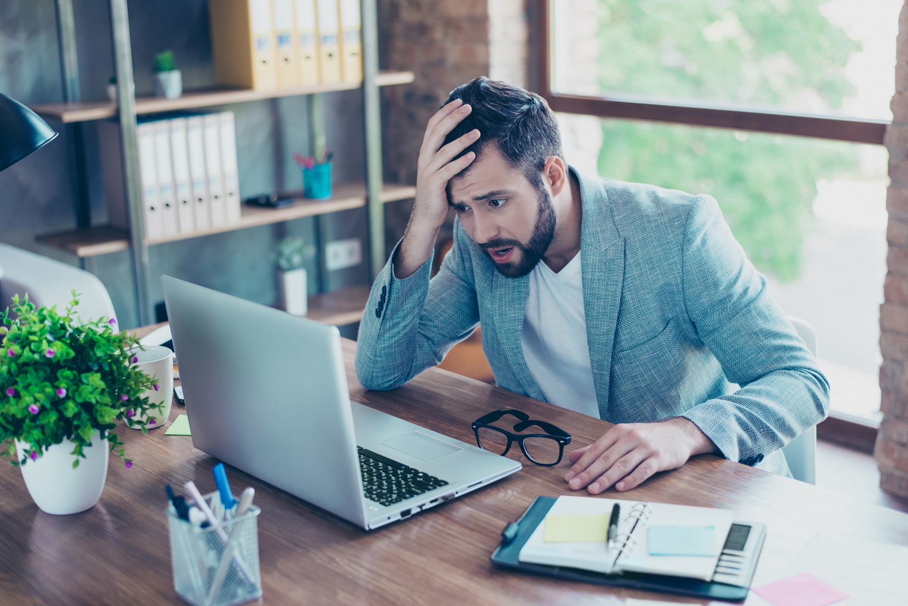 man looking at his laptop worried