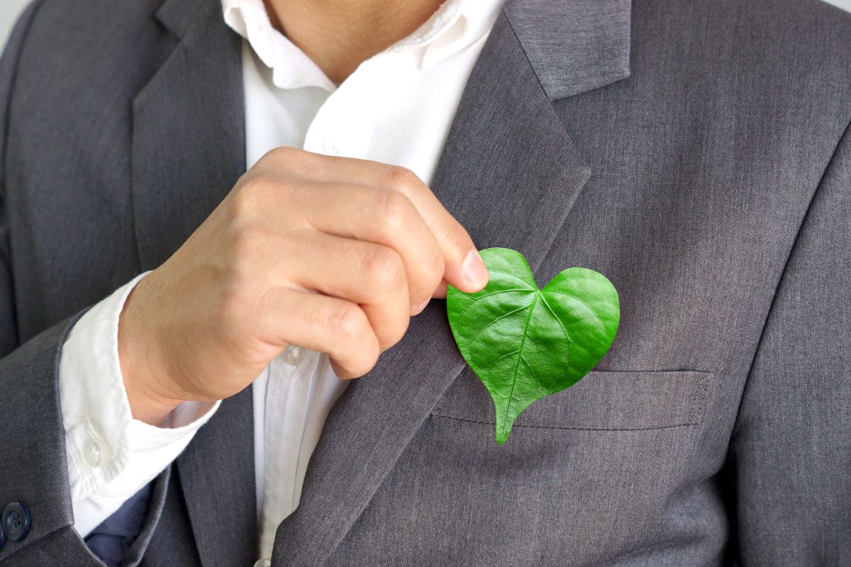 business man holding heart shaped leaf