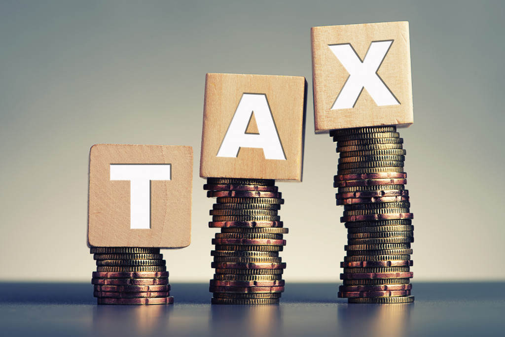 Tax wooden blocks on top of stacked coins