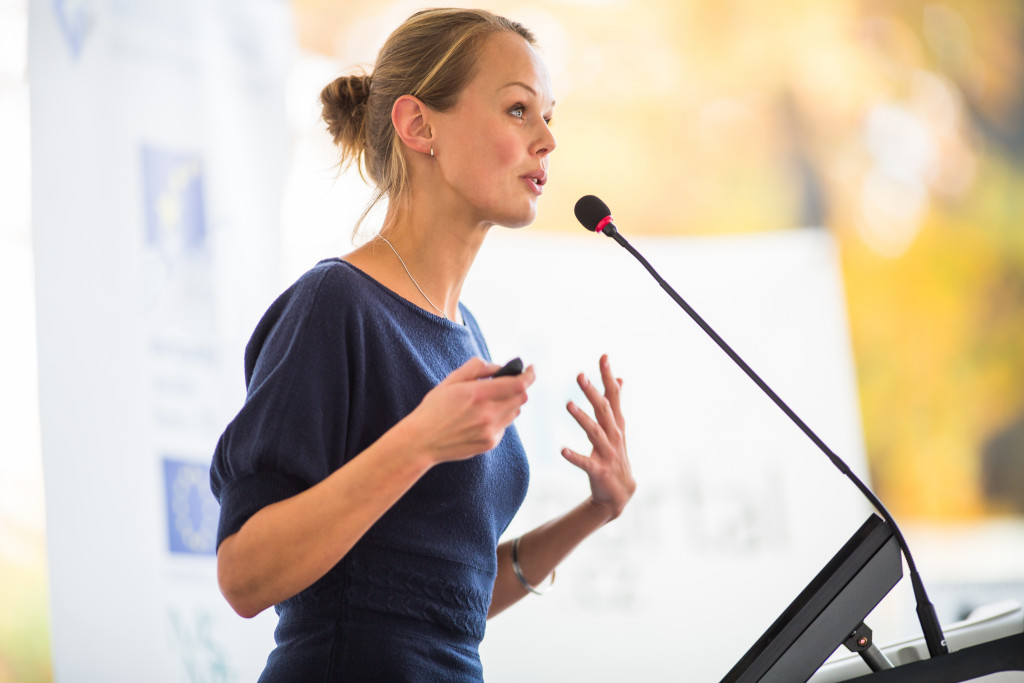 Woman presenting at a conference on the podium