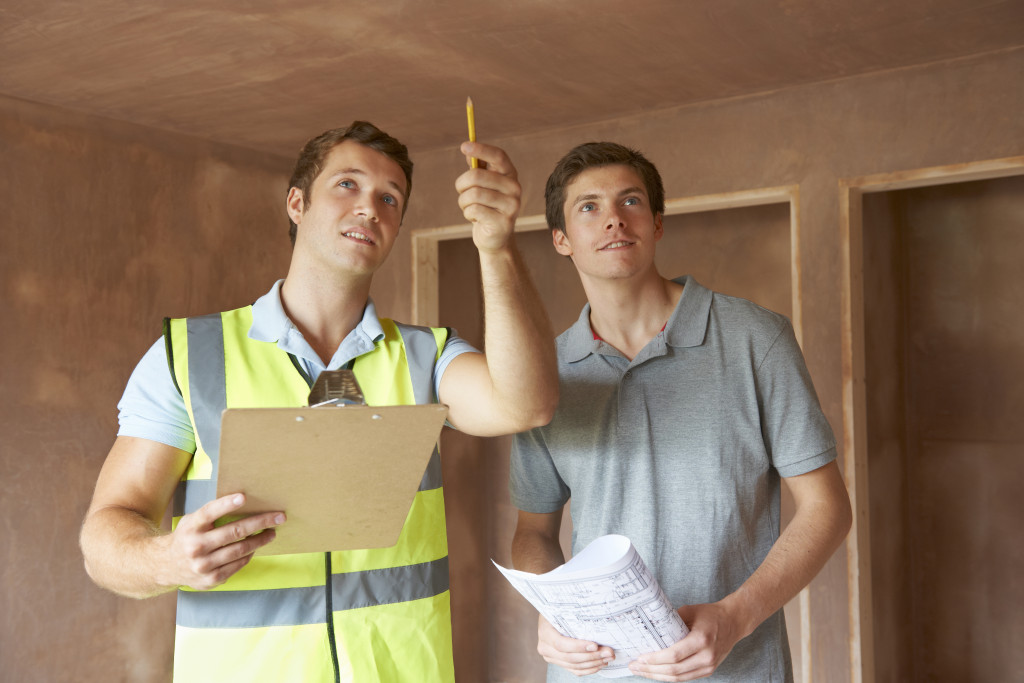 a home inspector pointing at something while a home buyer looks