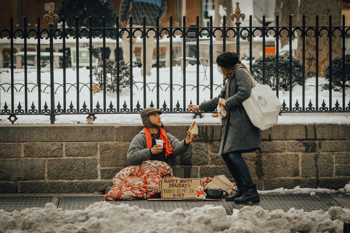 woman giving to homeless person