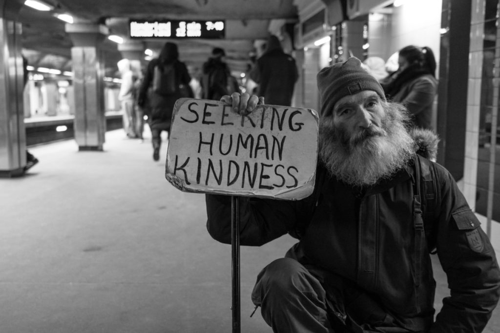 homeless man hold "seeking human kindness"