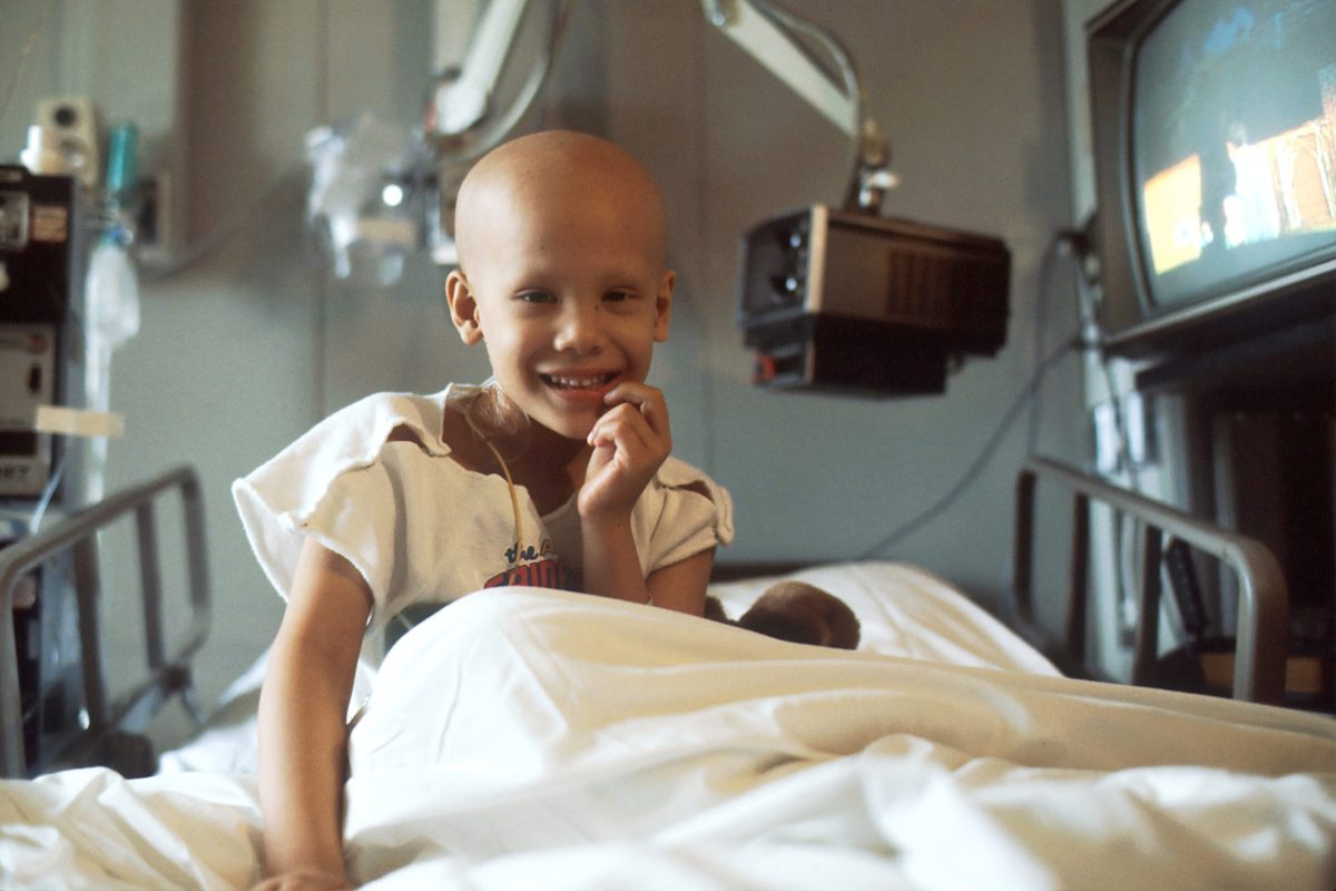 child sitting on hospital bed