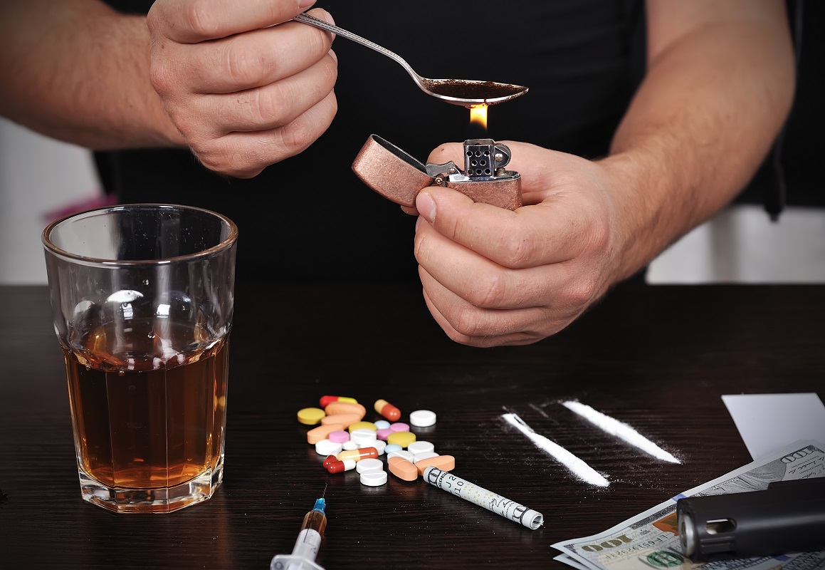 man prepares drug in spoon, close up