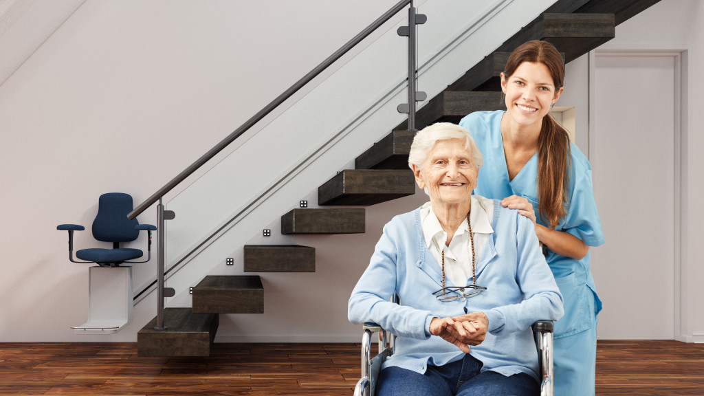 a senior woman with nurse at a home with lift chair near the stairs