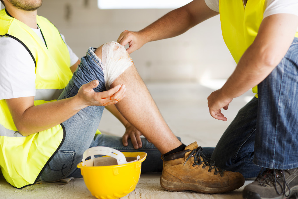 Construction worker receiving first aid after an accident at work.