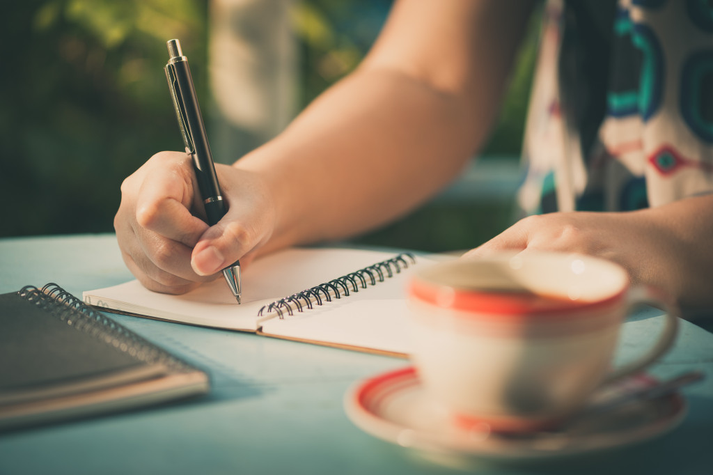 A woman writing on a notebook