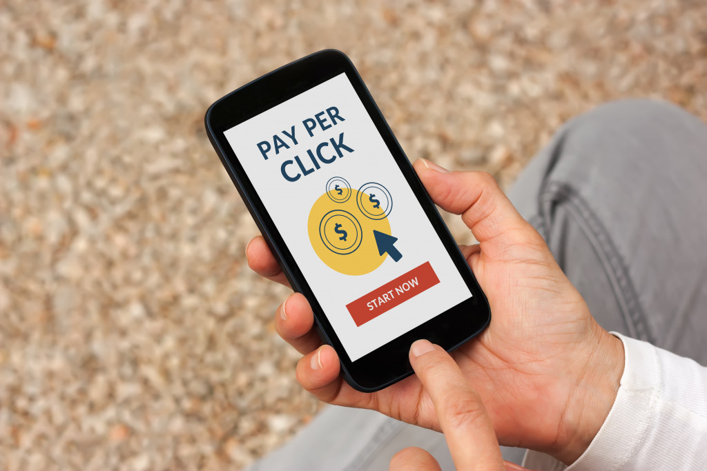 man holding a phone with pay per click display