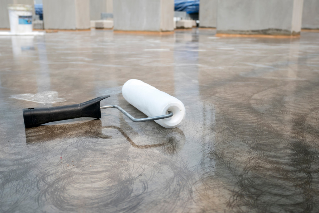 A paint roller on concrete floor