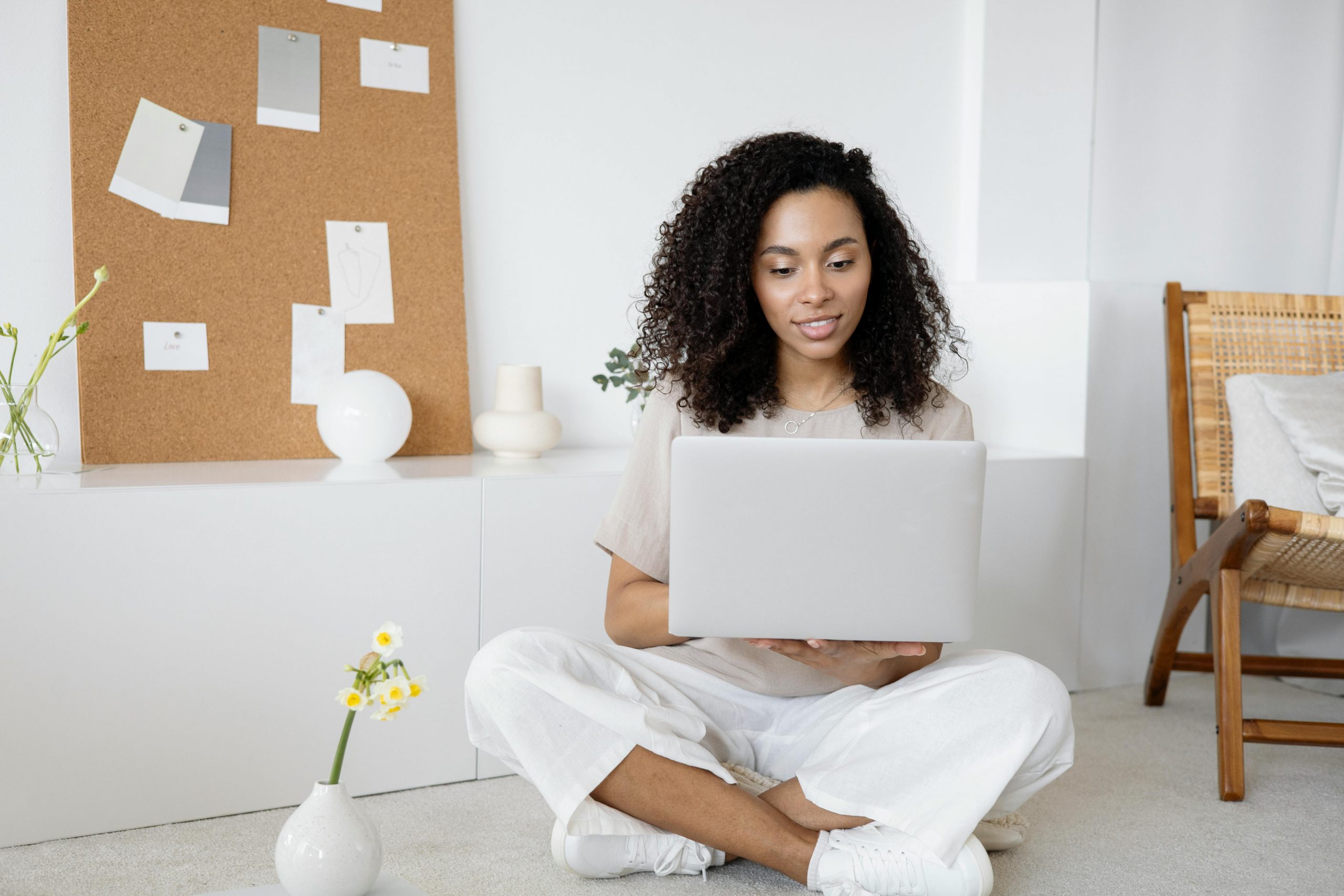 woman sitting on the floor while holding a laptop